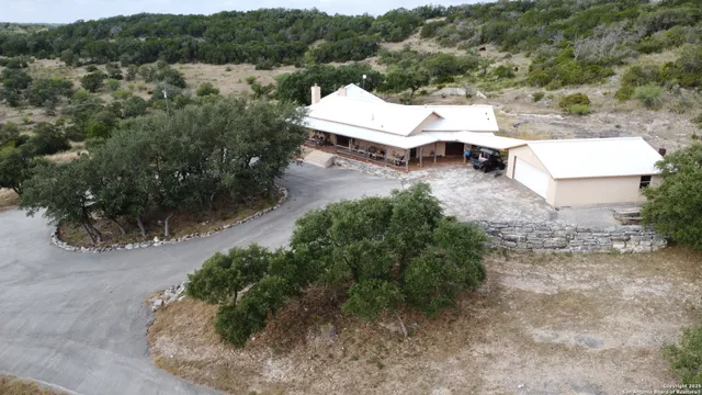an aerial view of a house with a yard and lake