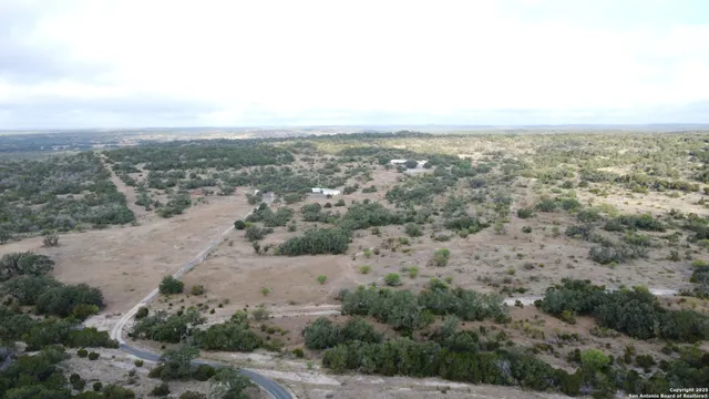 an aerial view of house with yard and mountain view in back