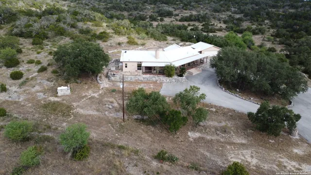 a view of a white house with a yard and sitting area