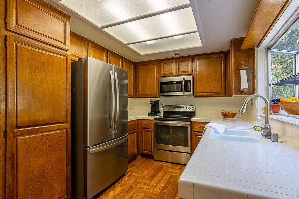 4738 Gateshead Road Carlsbad, CA 92010 - Photo 11 of 36 a kitchen with stainless steel appliances granite countertop a refrigerator stove and sink