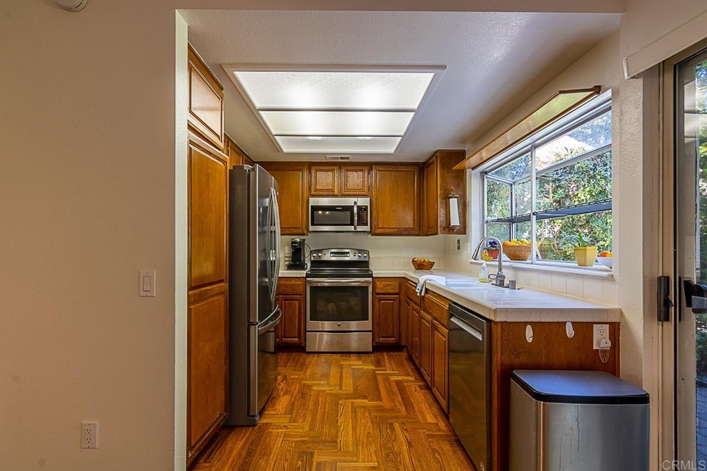 4738 Gateshead Road Carlsbad, CA 92010 - Photo 12 of 36 a kitchen with stainless steel appliances granite countertop a sink a stove and a refrigerator