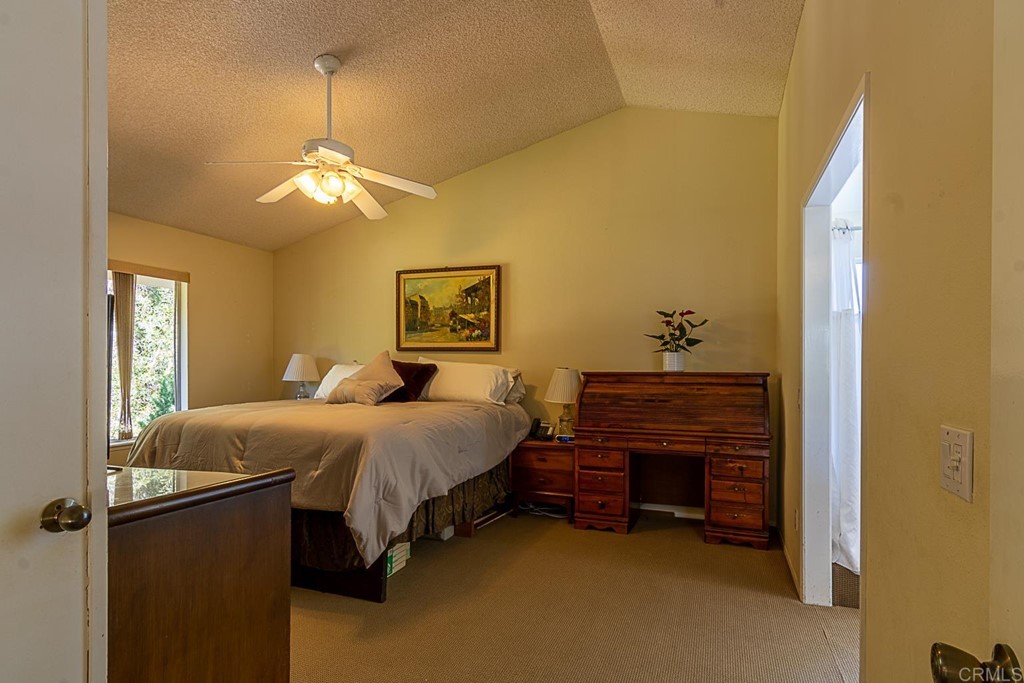 4738 Gateshead Road Carlsbad, CA 92010 - Photo 14 of 36 a bedroom with a bed and a chandelier