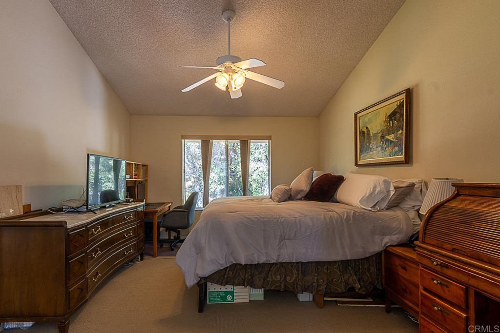 4738 Gateshead Road Carlsbad, CA 92010 - Photo 18 of 36 a bedroom with a bed and a chandelier