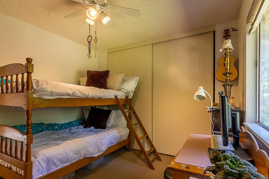 4738 Gateshead Road Carlsbad, CA 92010 - Photo 19 of 36 a bedroom with a bed and a chandelier