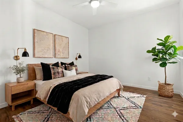 a bedroom with a bed lamp and a potted plant
