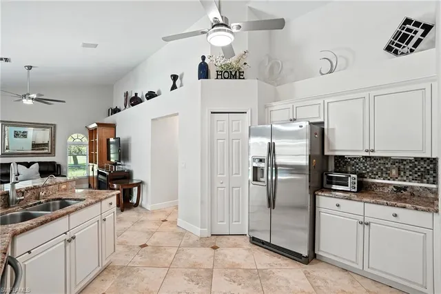 a kitchen with stainless steel appliances a refrigerator sink and cabinets