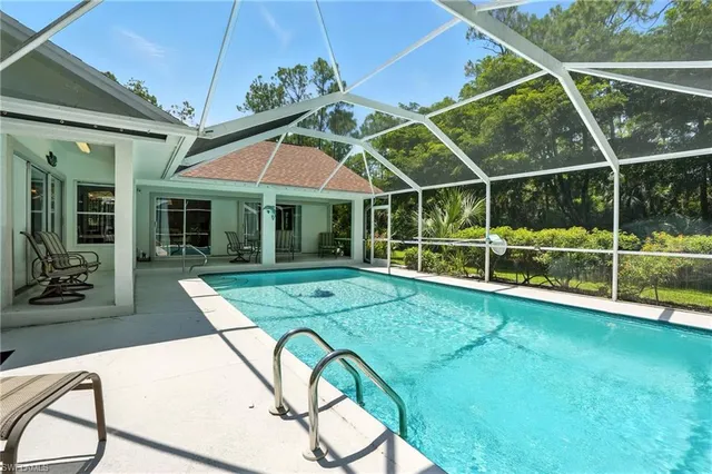 a view of a backyard with table and chairs under an umbrella