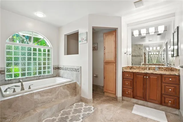 a spacious bathroom with a granite countertop sink a large mirror and a shower