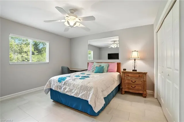 a bedroom with a bed chandelier and a window