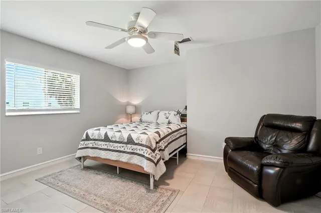 a bedroom with bed couch and window