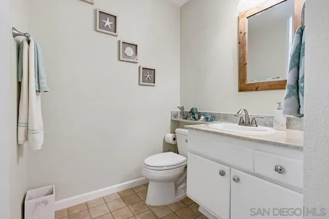 a bathroom with a toilet a sink a mirror and vanity