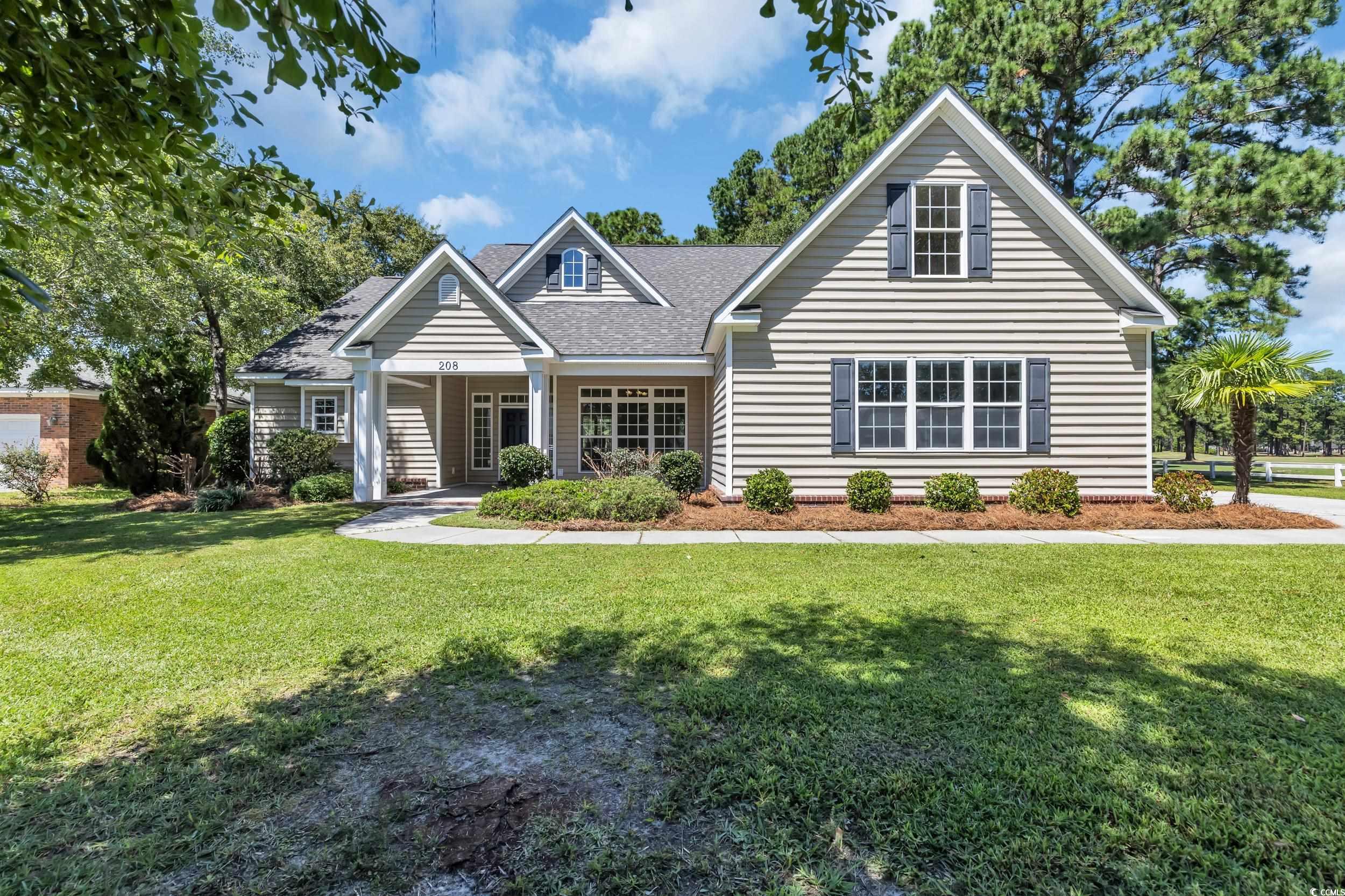 View of front of house featuring covered porch, a front lawn, and roof with shingles