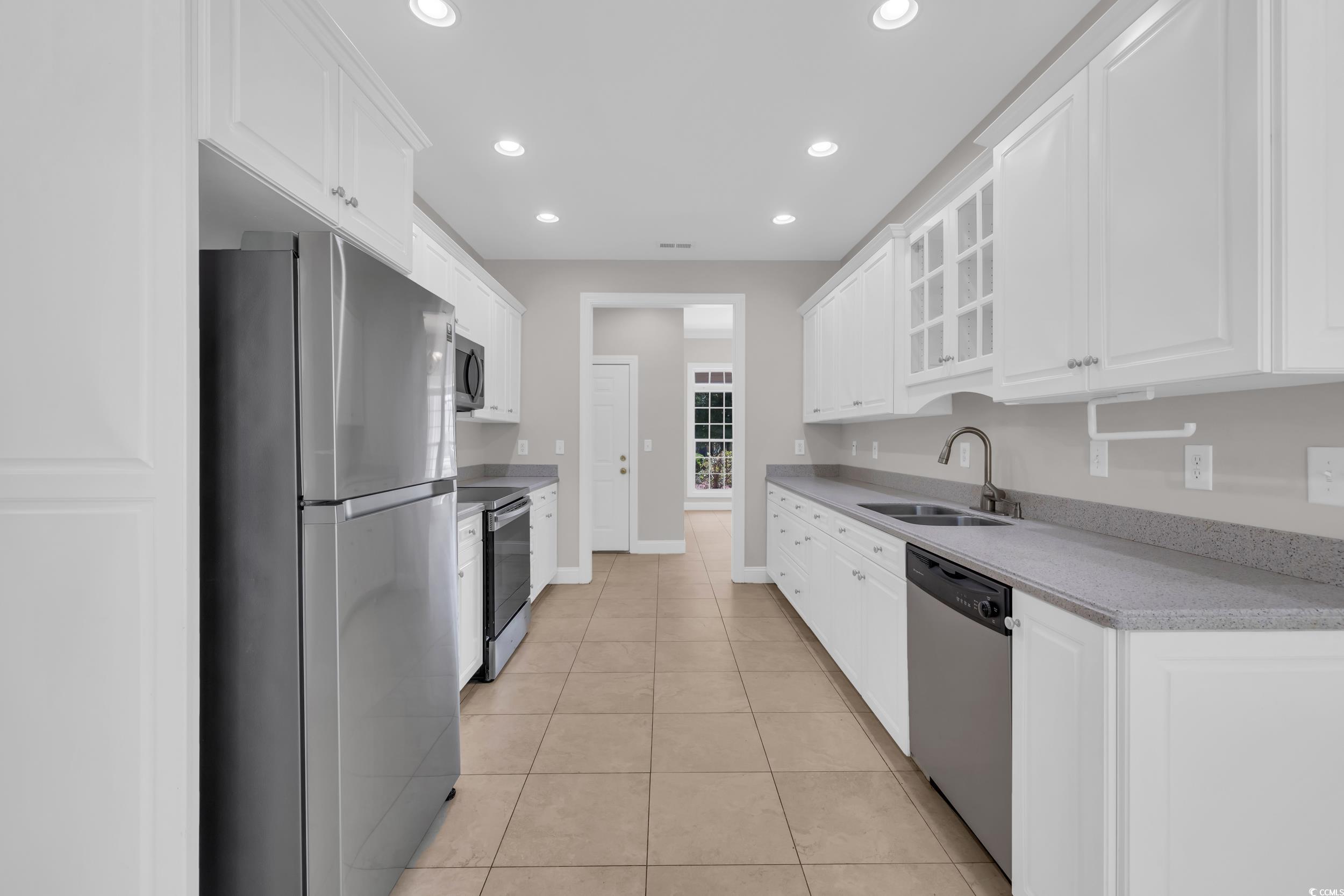 208 Lander Drive Conway, SC 29526 - Photo 4 of 40 Kitchen with appliances with stainless steel finishes, white cabinets, recessed lighting, glass insert cabinets, and light tile patterned flooring