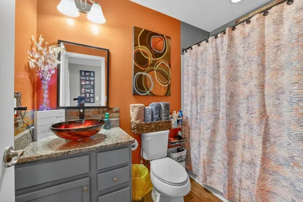 a bathroom with a granite countertop toilet sink and mirror