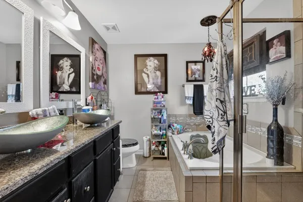a bathroom with a granite countertop sink a mirror and shower