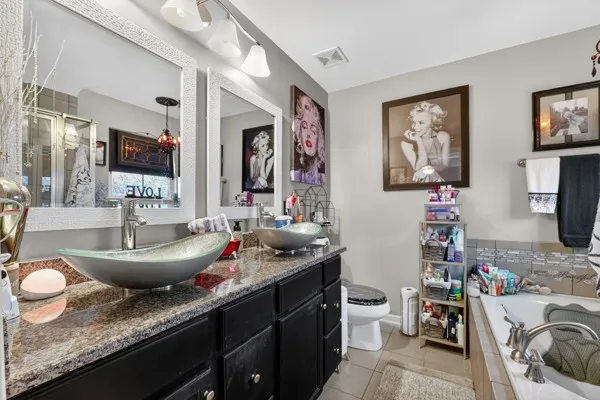 a bathroom with a granite countertop sink mirror and toilet