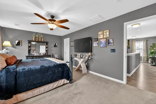 a bedroom with a bed and a flat tv screen on wall