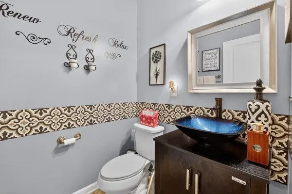 a bathroom with a granite countertop toilet sink and mirror