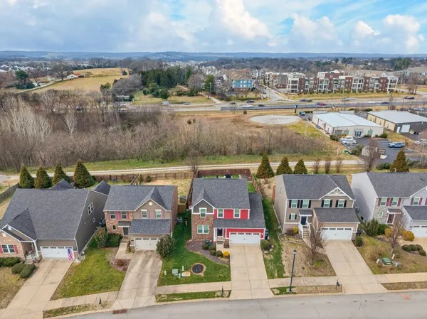 an aerial view of residential houses with outdoor space and lake view