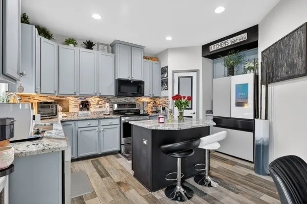 a kitchen with a refrigerator cabinets and wooden floor