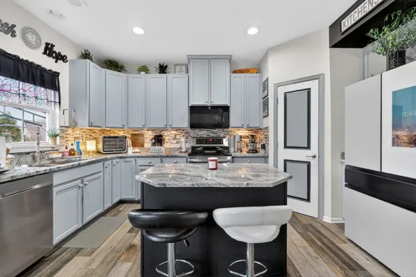 a kitchen with stainless steel appliances granite countertop a sink stove and refrigerator