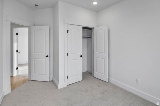 412 West 3025th Street South Logan, UT 84321 - Photo 23 of 34 Unfurnished bedroom with light carpet, a closet, and recessed lighting