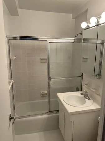 a bathroom with a shower sink vanity and toilet