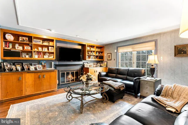 a living room with furniture a flat screen tv and kitchen view