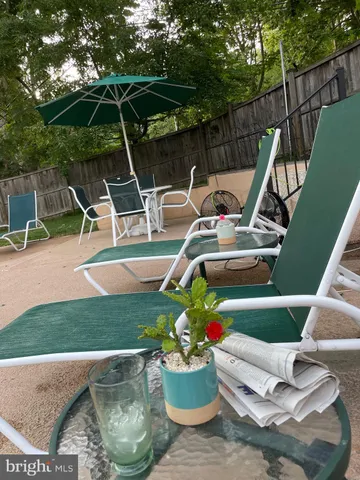 a view of a patio with table and chairs potted plants