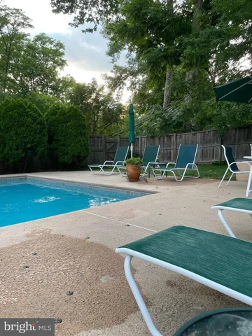 a view of back yard with swimming pool and seating area