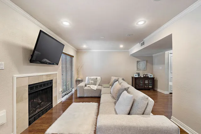 a living room with furniture a fireplace and a flat screen tv