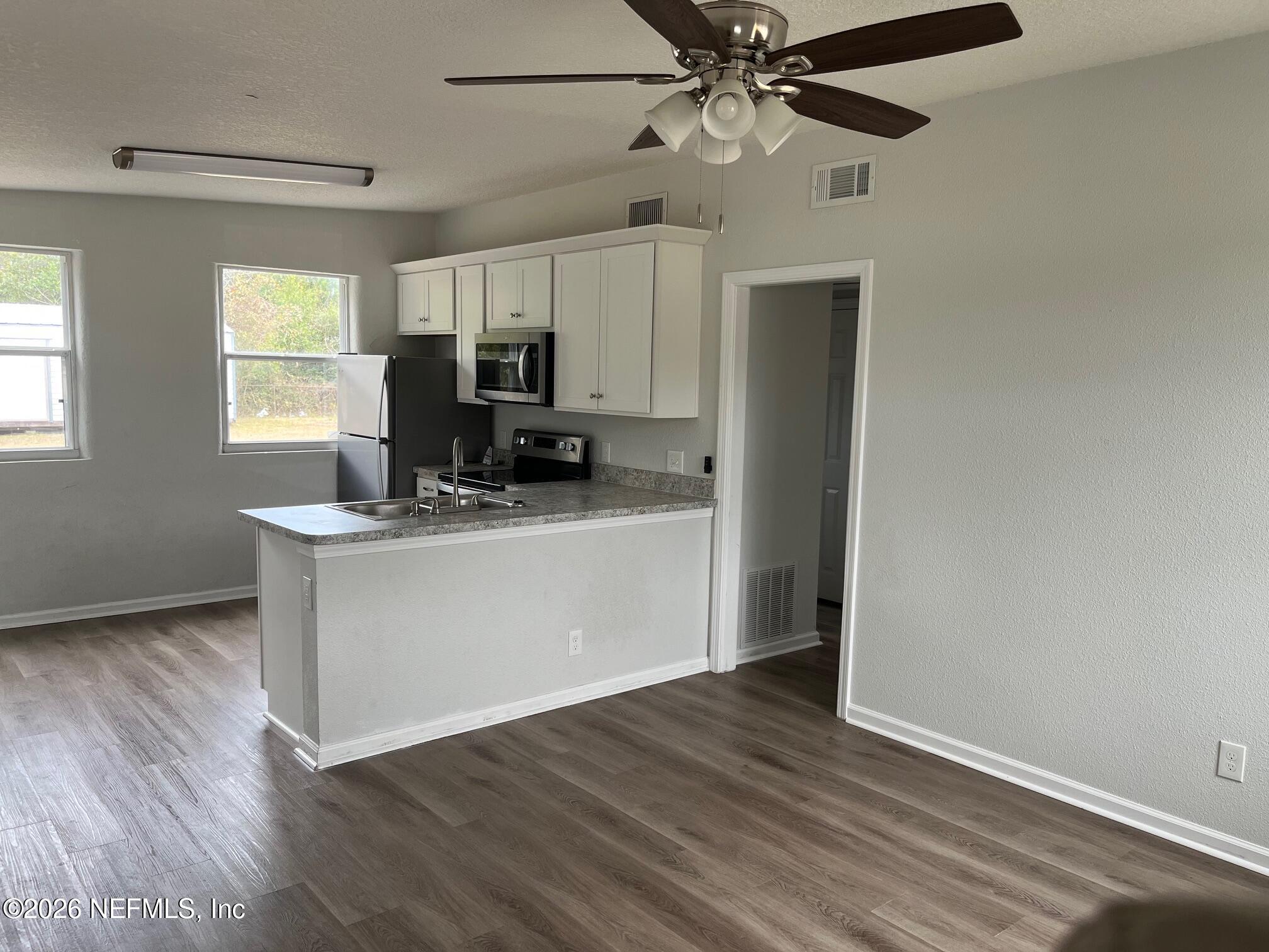 10547 Briarcliff Road East Jacksonville, FL 32218 - Photo 5 of 33 a kitchen with a refrigerator and a stove top oven