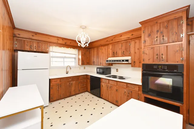a kitchen with a sink a stove cabinets and wooden floor