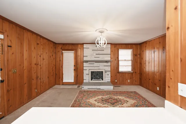 a view of an empty room with a fireplace and a window