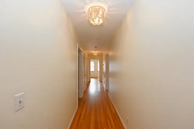 a view of a livingroom with wooden floor and a ceiling fan