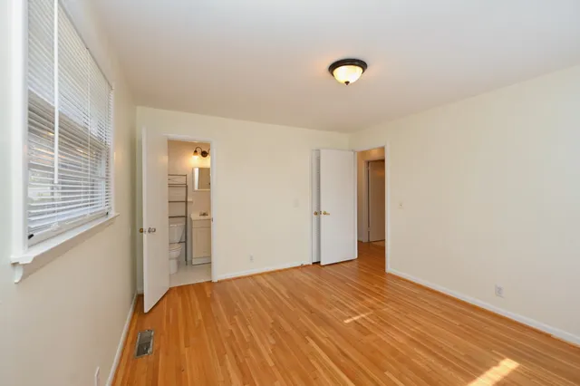 a view of a room with a wooden floor and white walls