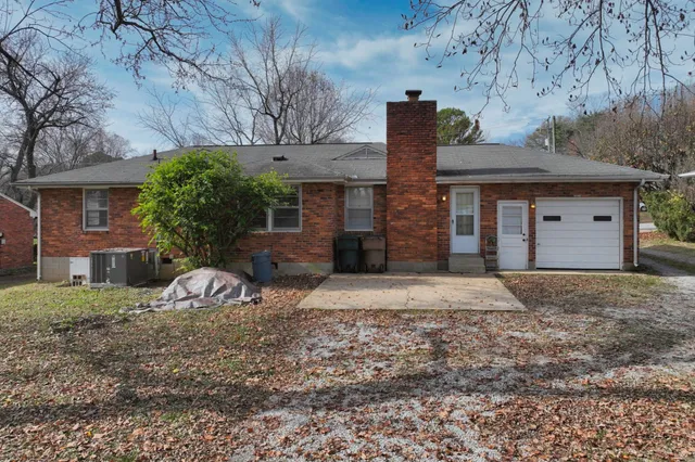 a view of a yard with plants and trees