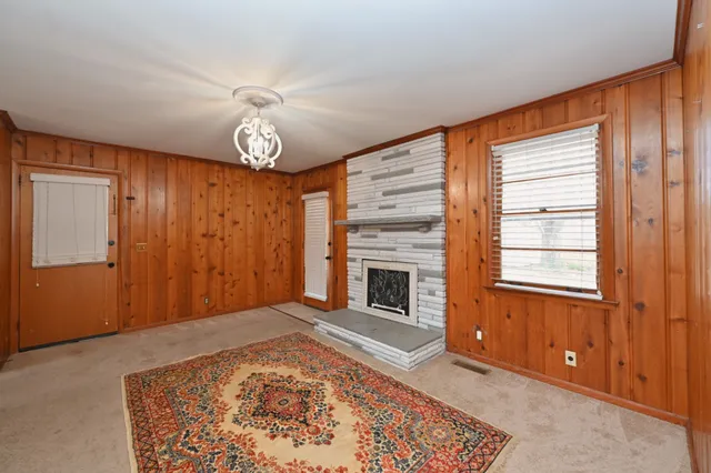 a view of an empty room with a fireplace and a window