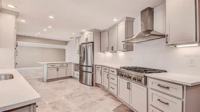 a kitchen with stainless steel appliances granite countertop a stove a sink and a refrigerator