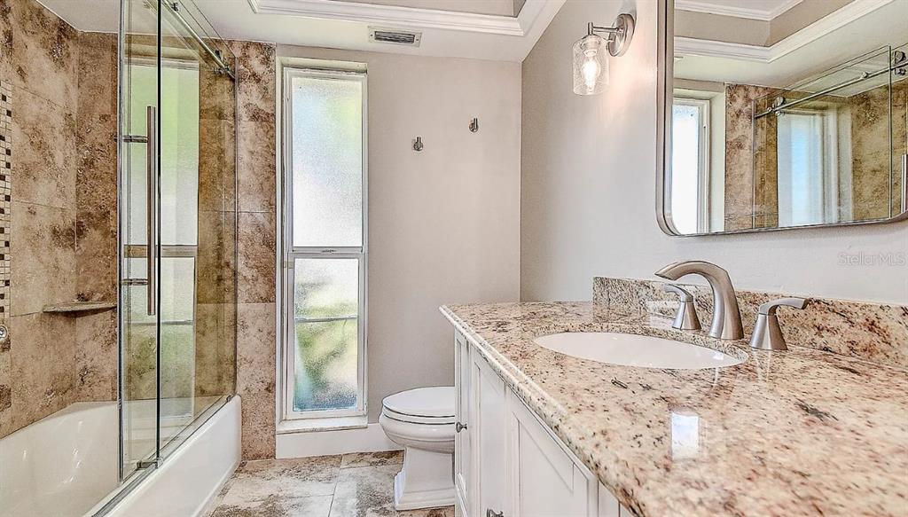 1998 Kansas Avenue Northeast St. Petersburg, FL 33703 - Photo 10 of 14 a bathroom with a granite countertop sink toilet and shower