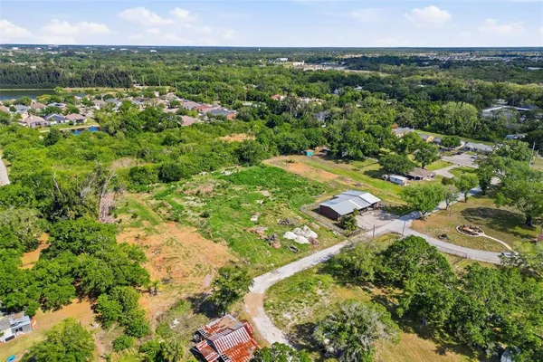 an aerial view of residential houses with outdoor space and trees