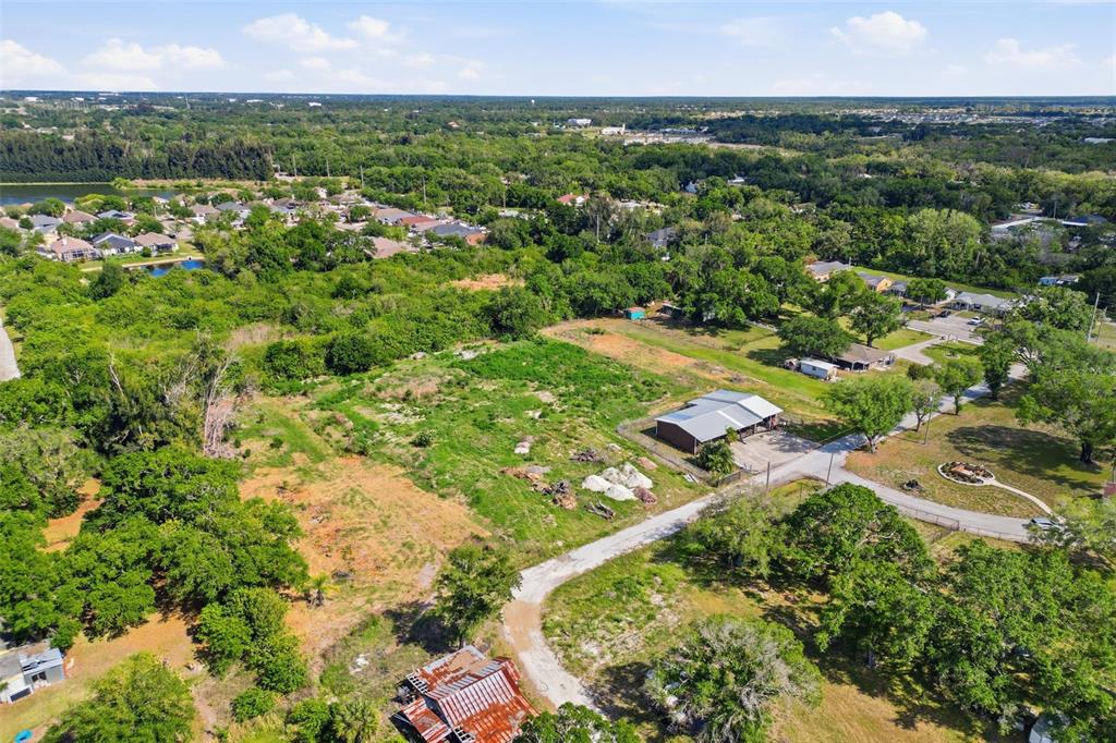 an aerial view of residential houses with outdoor space and trees