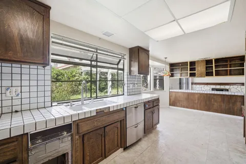 a kitchen with a sink a window and cabinets