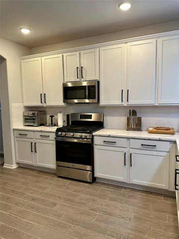 a kitchen with stainless steel appliances a stove a sink and a microwave