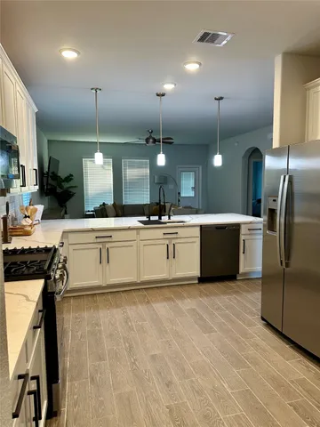 a large kitchen with kitchen island a sink stainless steel appliances and cabinets