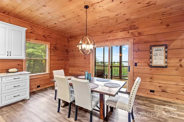 a dining room with furniture a chandelier and wooden floor