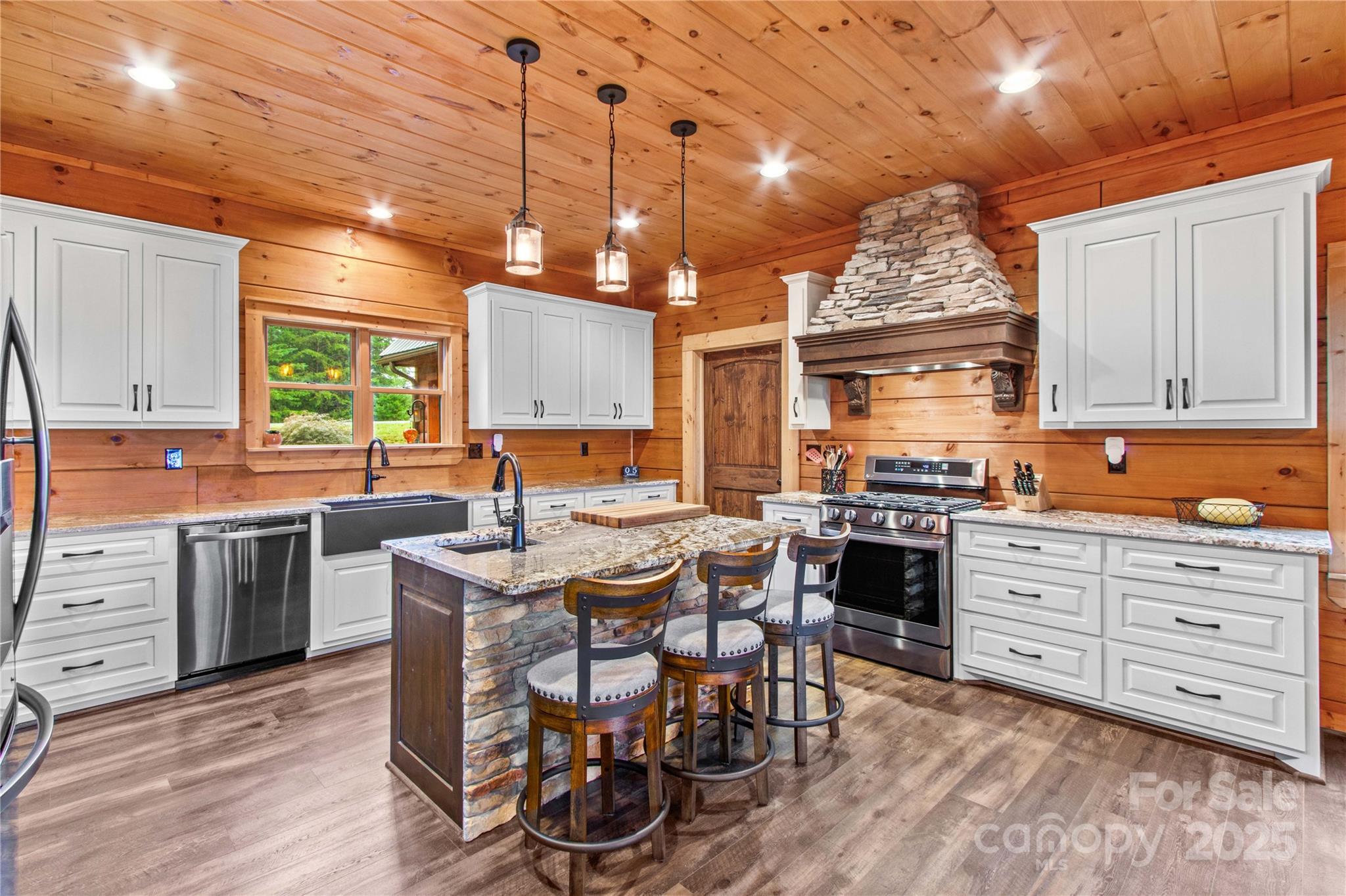 1220 Sierra Trace Road Denton, NC 27239 - Photo 20 of 48 a kitchen with stainless steel appliances kitchen island granite countertop a table chairs stove and cabinets