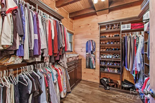 a view of walk in closet with clothes and shoes