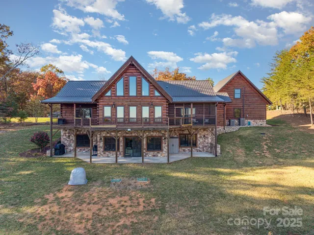 a aerial view of a house with swimming pool and trees in the background