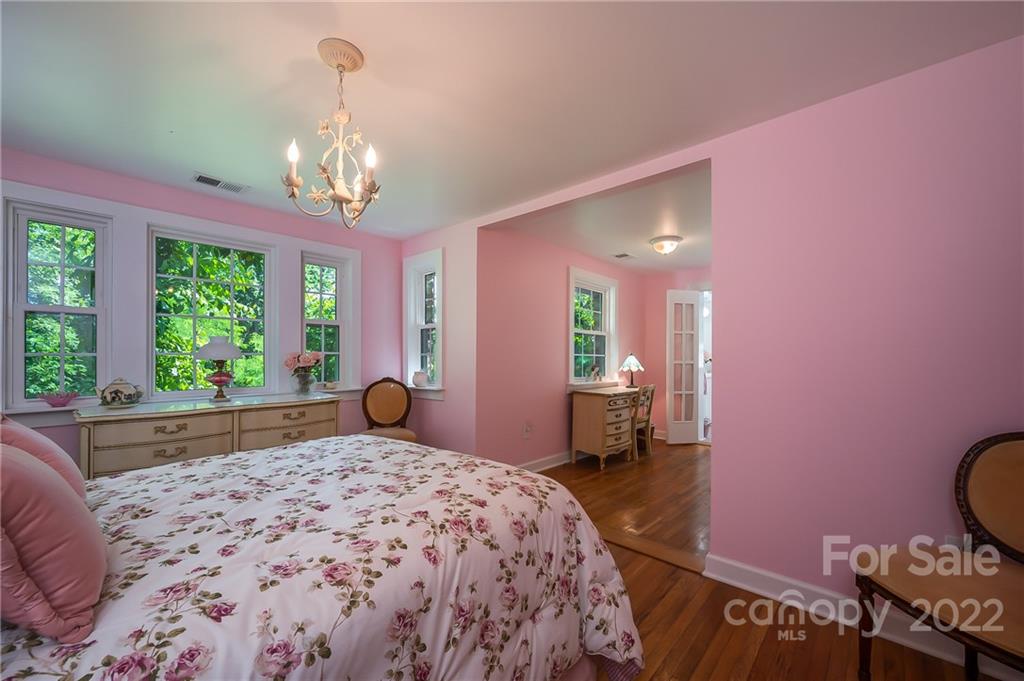 146 Hidden Hill Road Tryon, NC 28782 - Photo 18 of 43 a bedroom with a bed and a chandelier
